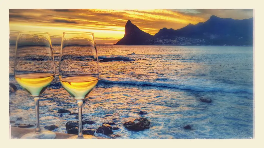 Ein Glas Wein beim Sonnenuntergang im Tintswalo Atlantic in Hout Bay, Kapstadt, Südafrika.