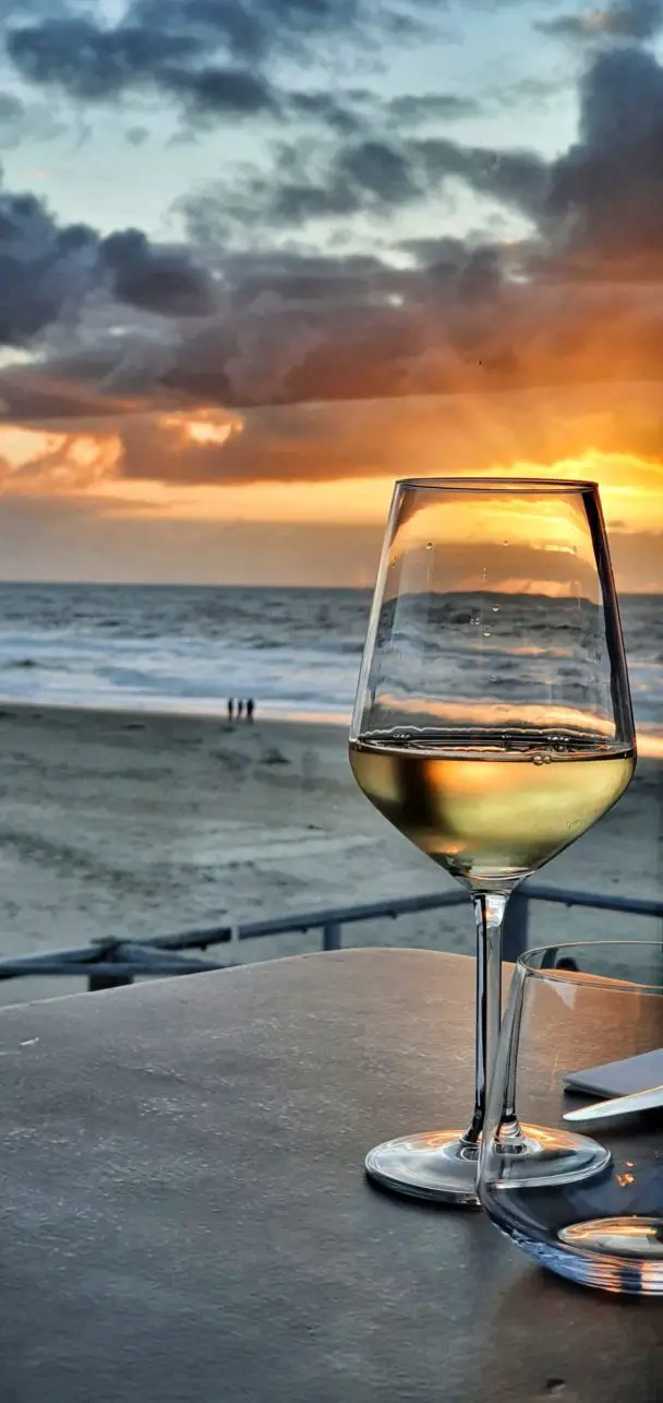 Wein bei Sonnenuntergang am Strandpaviljoen Paal 17 Aan Zee auf Texel, Niederlande.